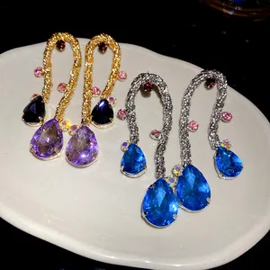 Close-up detail of vintage woven tassel earrings featuring vibrant blue and purple teardrop gems