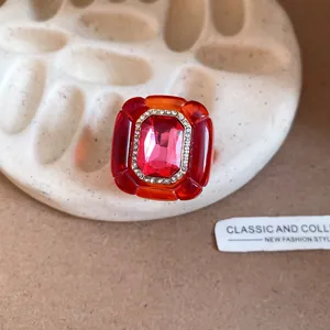 Macro detail of a vintage palace style resin ring with pink gemstone and rhinestones