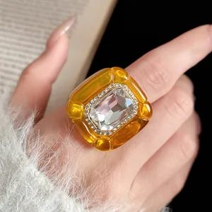 Close-up of vintage amber resin ring with central crystal and rhinestone details
