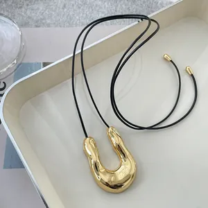 Elegant minimalist gold U-shaped pendant necklace with adjustable black leather cord