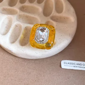 Close-up of yellow resin vintage ring with clear crystal cluster and rhinestone accents