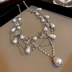 Detail view of a silver-tone butterfly necklace with elegant teardrop pearls and rhinestones.