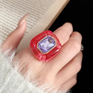 Detailed view of vintage resin ring featuring purple gemstone and wrinkled red texture