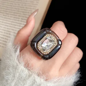 Close-up view of vintage black resin ring with large crystal and rhinestone border