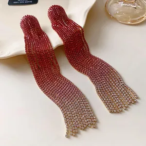 Nahaufnahme glitzernder Strass-Ohrringe mit rotem Farbverlauf und silberner Nadel