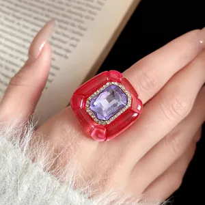 Detailed view of a vintage resin ring with pleated texture and purple gemstone