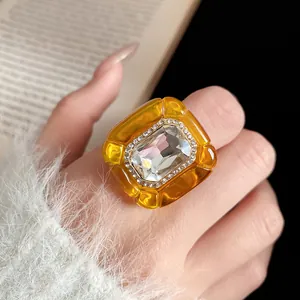 Detail of vintage court style amber resin ring with a large central crystal.