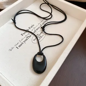 Elegant black oval ceramic pendant necklace with minimalist cord for retro fashion style