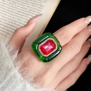 Close-up detail of a vintage court style resin ring featuring a large red center stone