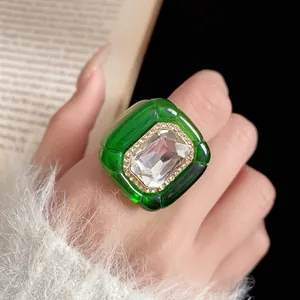 Close-up of green resin ring with pleated texture and central rhinestone inlay