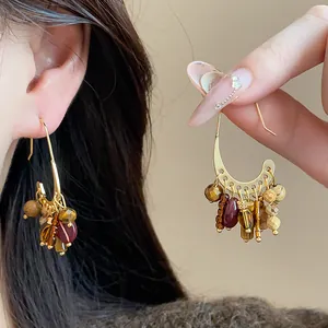 Detail of gold-plated vintage hoop earrings featuring vibrant bohemian stone tassels
