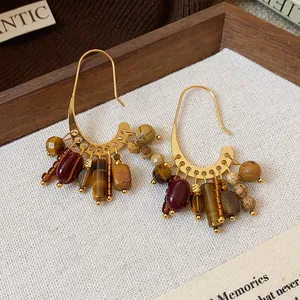 Close-up of vintage gold plated earrings with colorful natural stone tassel beads