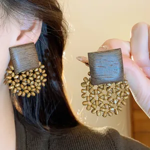 Detail of retro geometric wood earrings with handcrafted bead cluster and wood grain