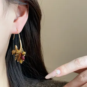 Detailed close-up view of vintage gold plated earrings with colorful natural stone tassels