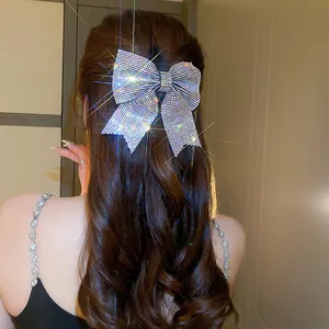 Elegant sparkling silver crystal bow hair clip accessory shown on model from the back view