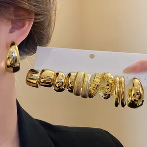 Macro view of various gold earrings in a set, featuring pleated and irregular vintage designs