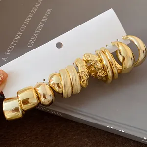 Detailed view of irregular gold wrinkled hoop earring set on white card display
