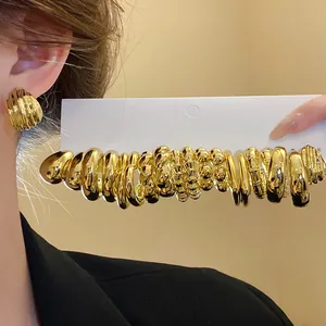 Macro detail view of vintage gold earrings set with irregular pleated and round designs.