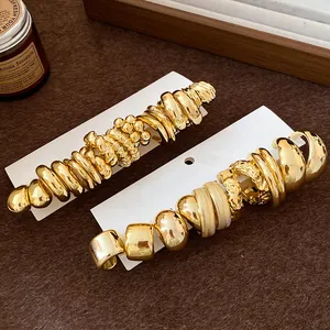 Detailed close-up of vintage gold chunky hoop earrings set on white display cards