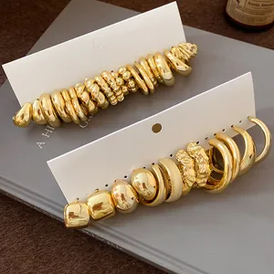 Detailed view of irregular gold earring set displayed on white cards with vintage style