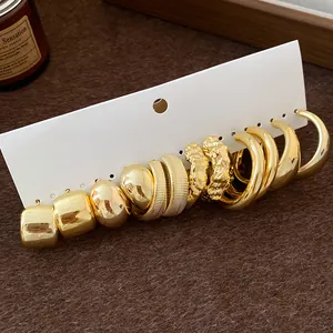 Detailed view of gold irregular textured hoop earrings set on a white display card.