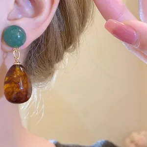 Vintage asymmetric resin water-drop earrings with green and amber stones for women.