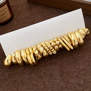Detail view of gold chunky earrings set with irregular pleated and smooth finishes