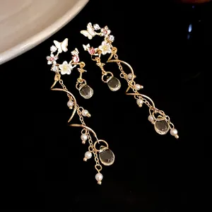 Elegant silver needle drop earrings featuring butterfly and flower crystal tassels.