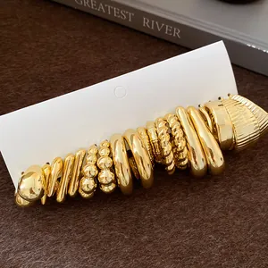 Detail view of an irregular pleated and round gold-tone earring set on white card.