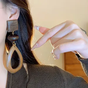 Close-up of vintage geometric wooden drop earrings with retro teardrop design