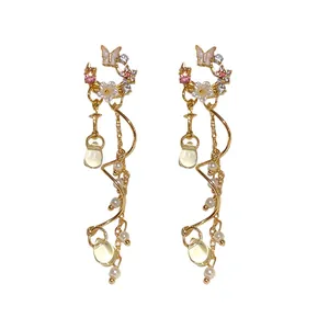 Elegant gold-tone butterfly and flower tassel earrings with crystals and faux pearls