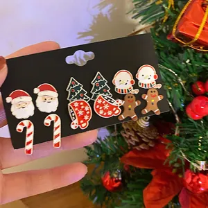 Festive Christmas stud earring set with Santa Claus and tree designs on display card.