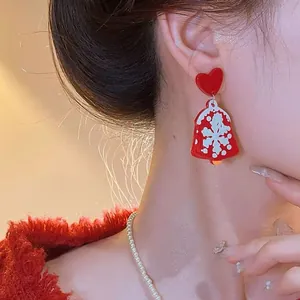 Festive red Christmas bell drop earrings featuring snowflake pattern and heart stud