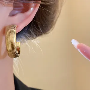 Close-up detail showing the elegant gold ribbed texture of the retro style hoop earrings