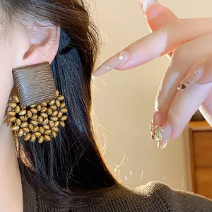Close-up of vintage geometric wooden stud earrings with circular bead details