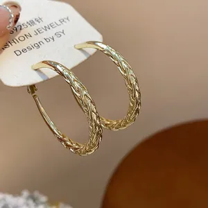 Detailed macro view of gold-plated hoop earrings with twisted texture on S925 silver needles