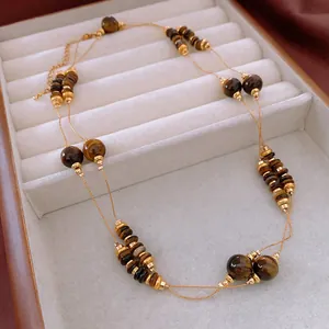 Elegant layered tiger eye beaded necklace with gold spacers displayed in a white jewelry box