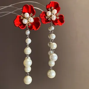 Detailed view of elegant vintage-style red flower earrings with cascading white pearls