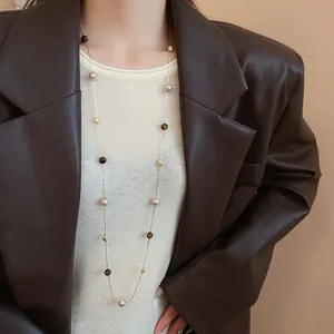 Detail view of Maillard style sweater chain necklace with oval synthetic tiger eye stones