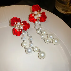 Close-up of vintage red flower earrings with long elegant pearl tassels