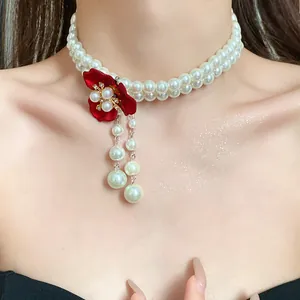 Elegant double-strand pearl choker necklace featuring a vintage red flower pendant design