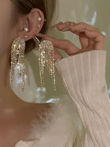 Detailopname van sprankelende strass franje hangoorbellen op model