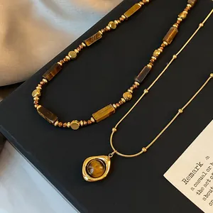 Sophisticated layered necklace set featuring brown tiger eye beads and golden finish