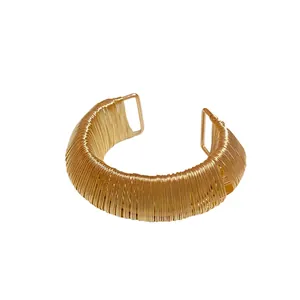 Bold gold wire-wrapped open cuff bracelet with a minimalist metallic woven design style