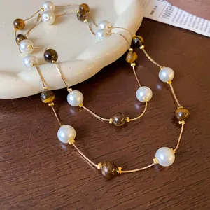 Collier double rang avec pierres œil de tigre et perles lustrées sur une chaîne dorée