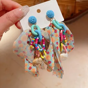 Colorful bohemian bow earrings with rice beads and seashell charms on steel needle.