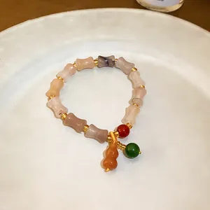 Macro detail view of Chinese style hulu jade bead elastic bracelet on ceramic plate