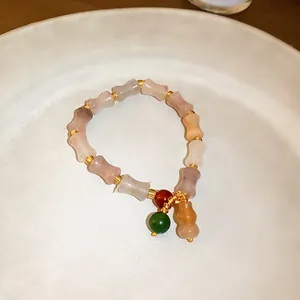 Macro view of New Chinese style jade bracelet with bone-shaped beads and hulu pendant