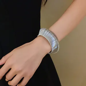 Detailed view of a silver metallic woven open cuff bracelet showcasing its textured surface