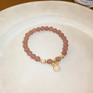Close-up view of a pink beaded bracelet featuring a cute rabbit charm on a white dish
